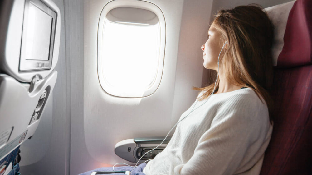 woman sleeping on plane with blanket