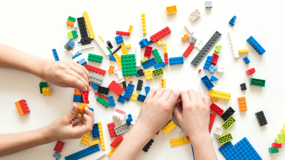 Children’s hands playing with Lego bricks