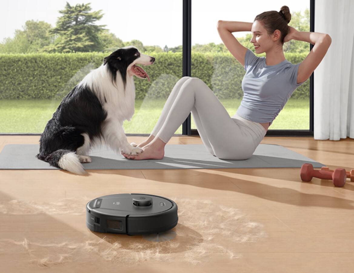 eufy vacuum with dog and woman doing yoga