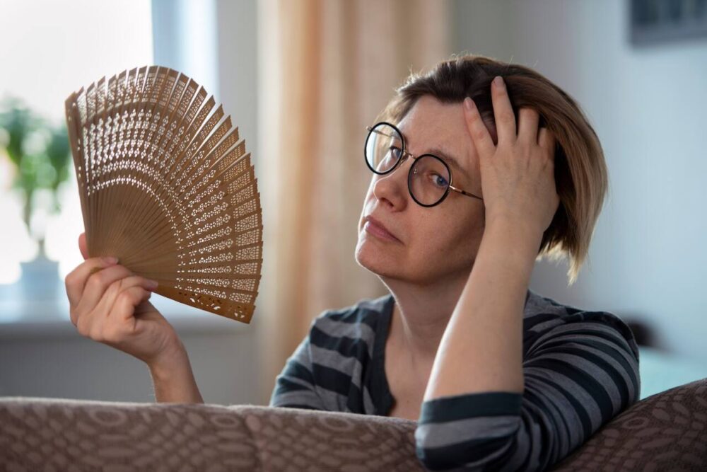 Woman fans herself during menopause hot flash