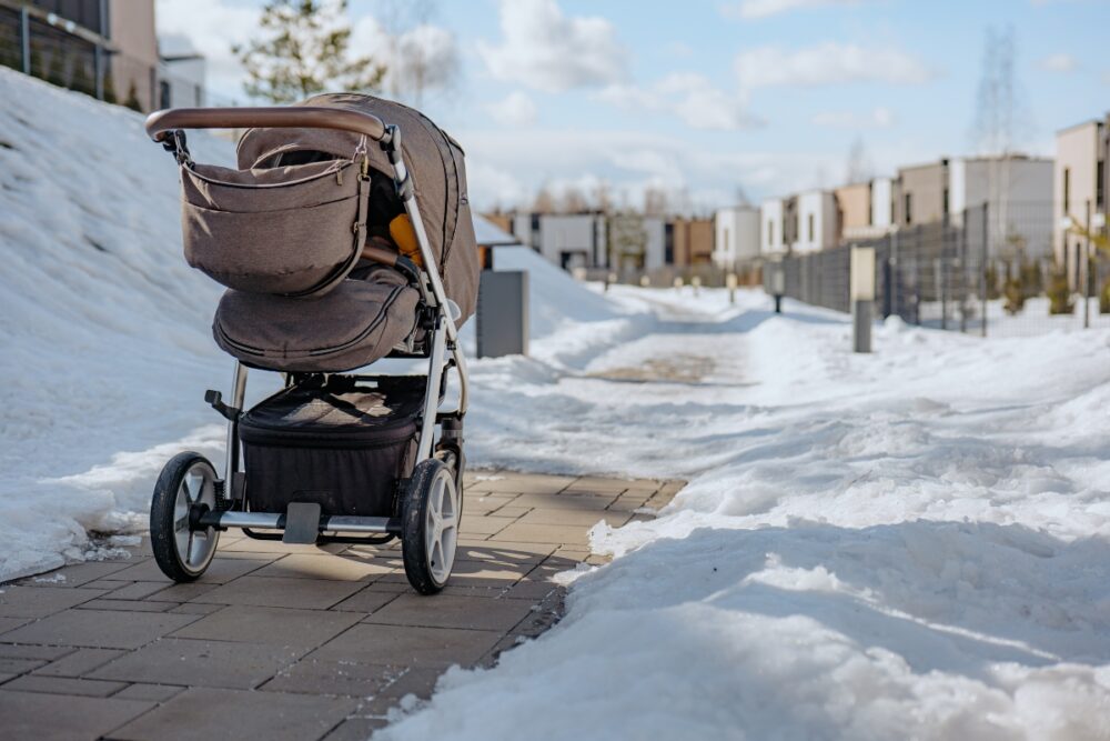 A baby in a stroller in the snow