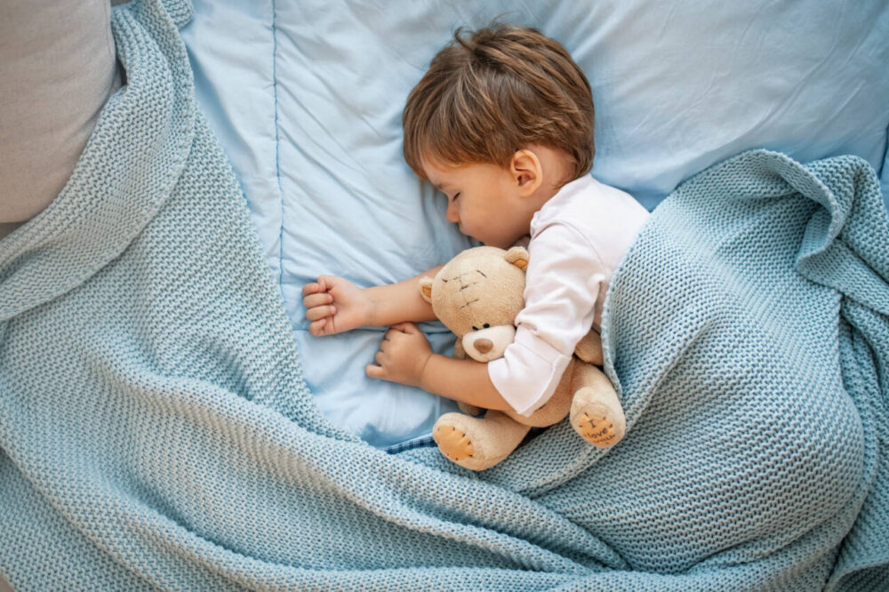 boy sleeping with teddy bear
