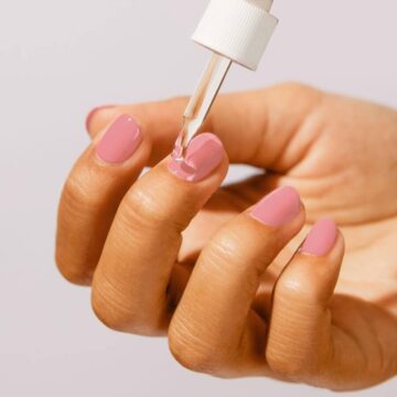 DIY pedicures - close up of cuticle oil being applied to finger nails