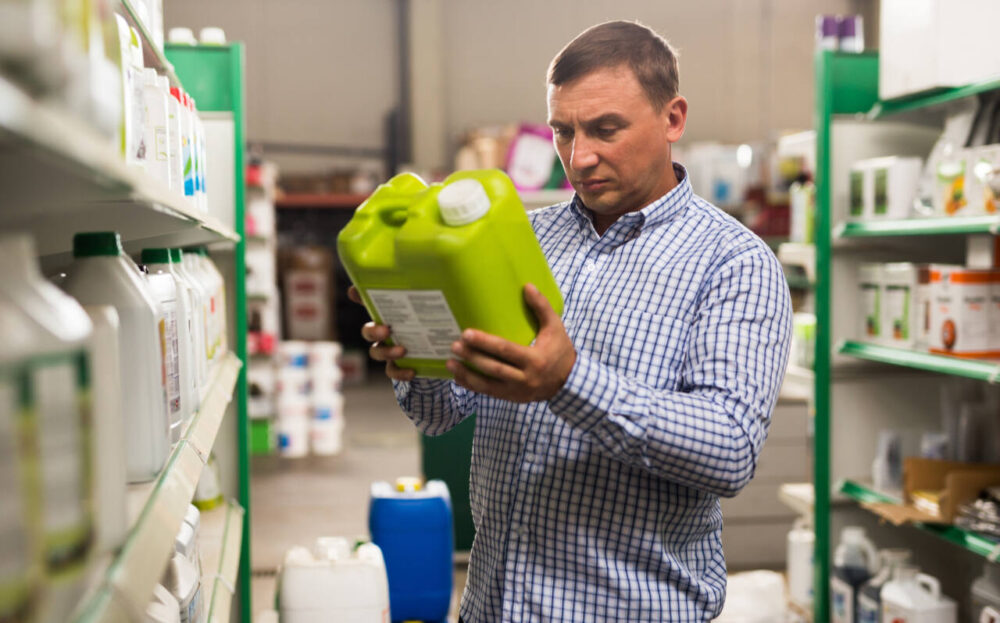Man looking at pesticide container in store
