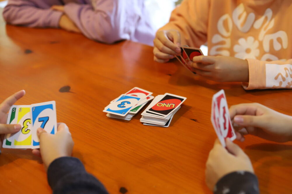 Group of children sitting around a table playing UNO