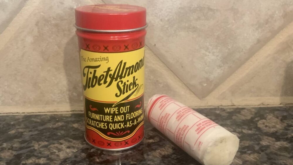 A container of the Tibet Almond Stick sits on a countertop.