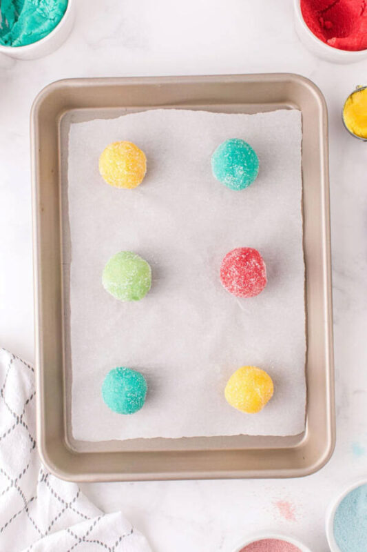 colorful cookie dough balls on baking sheet