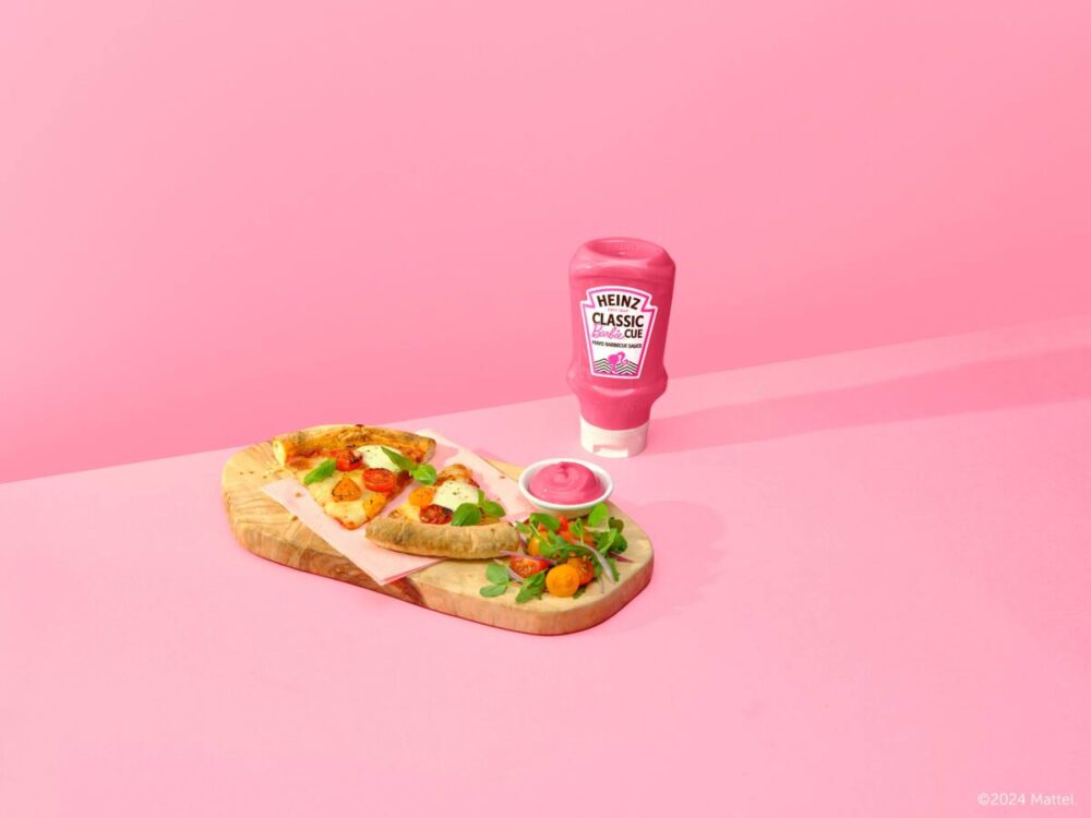 pink barbecue sauce bottle and pizza on a wood tray. 
