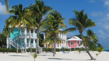 three colorful houses near a beach with palm trees