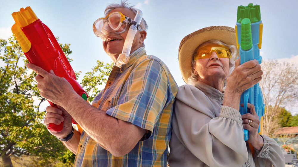 Two older people join a water fight